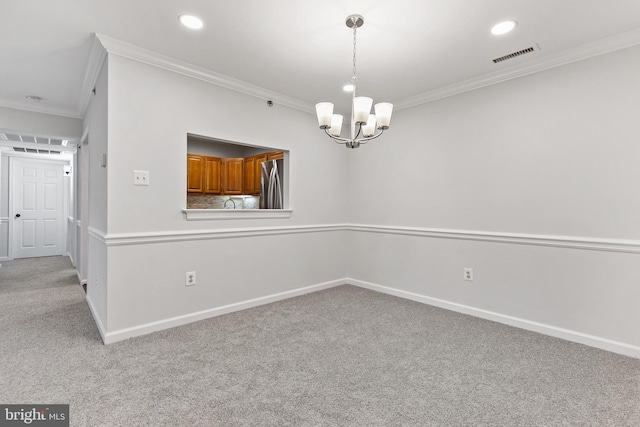 carpeted empty room with an inviting chandelier and ornamental molding