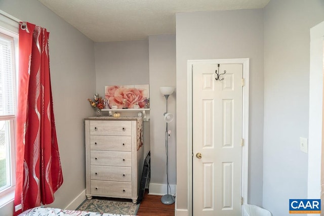 bedroom with dark hardwood / wood-style flooring