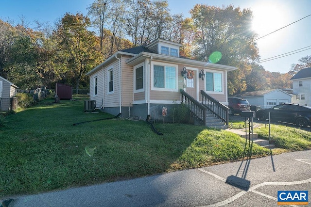 bungalow with a front yard and cooling unit