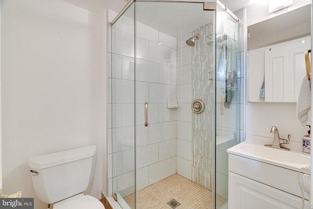 bathroom with a shower with door, vanity, and toilet