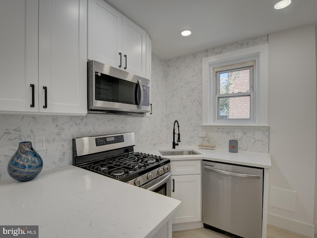 kitchen featuring light hardwood / wood-style flooring, appliances with stainless steel finishes, sink, and white cabinets