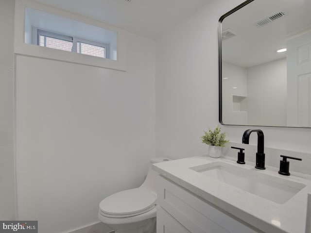 bathroom featuring toilet and vanity