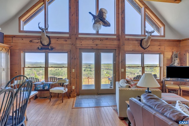 living room with light wood-type flooring, high vaulted ceiling, and plenty of natural light