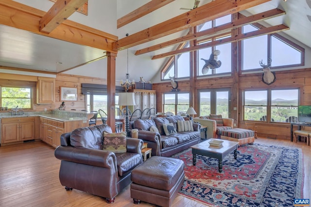 living room featuring sink, high vaulted ceiling, beamed ceiling, and light hardwood / wood-style flooring