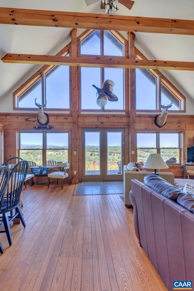 living room with beam ceiling, high vaulted ceiling, and a wealth of natural light