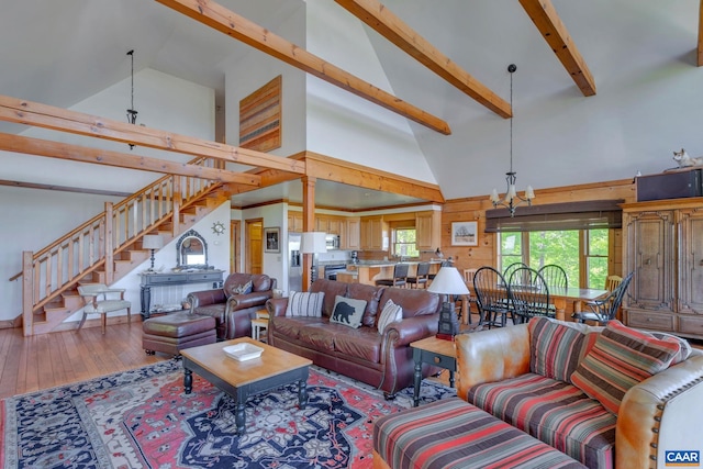 living room with hardwood / wood-style flooring, high vaulted ceiling, beam ceiling, and a chandelier