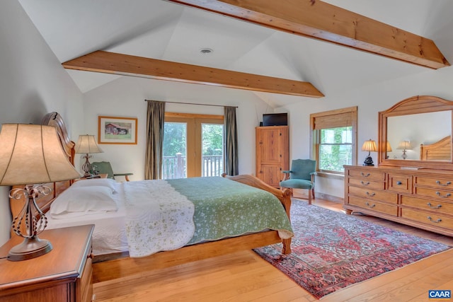 bedroom featuring hardwood / wood-style floors, vaulted ceiling with beams, multiple windows, and access to exterior