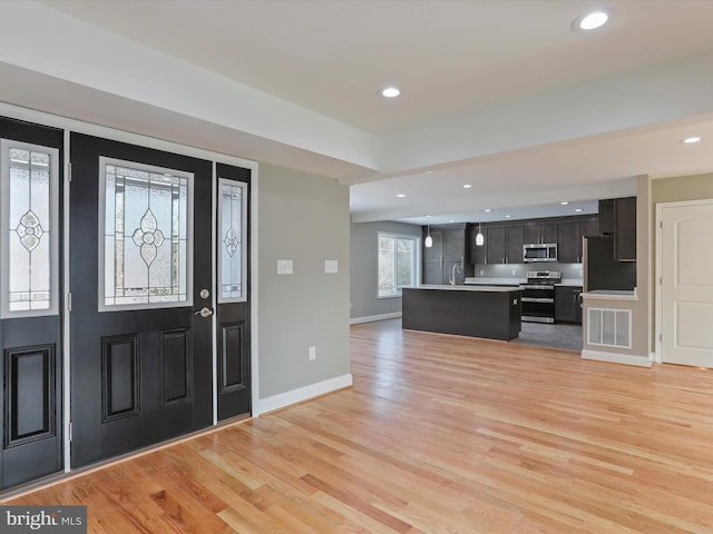 foyer entrance featuring baseboards, light wood-style floors, and recessed lighting