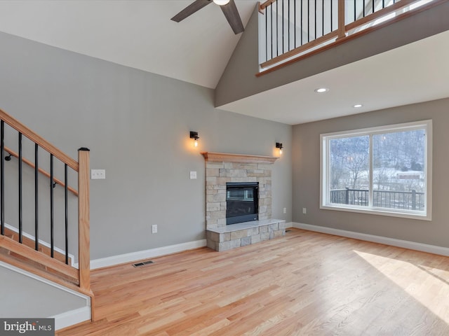 unfurnished living room featuring visible vents, wood finished floors, a ceiling fan, and high vaulted ceiling