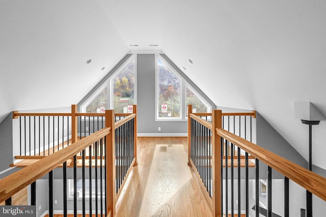 corridor with vaulted ceiling and light hardwood / wood-style floors