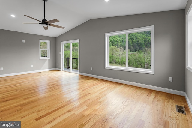 unfurnished room with lofted ceiling, visible vents, ceiling fan, light wood finished floors, and baseboards