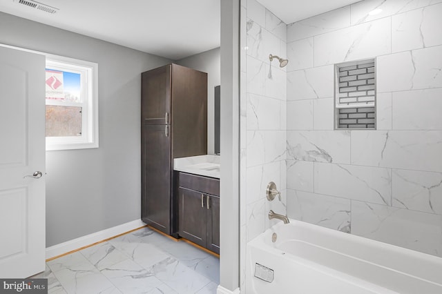 bathroom with tiled shower / bath combo and vanity