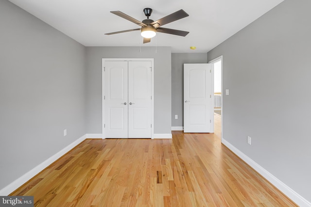 unfurnished bedroom with light wood-type flooring, ceiling fan, and a closet