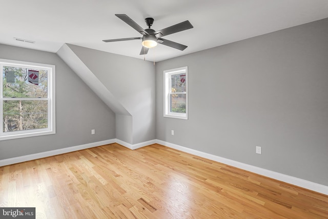 additional living space with vaulted ceiling, ceiling fan, light hardwood / wood-style floors, and a wealth of natural light