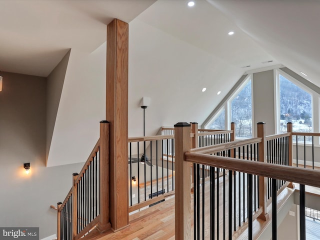 hall with lofted ceiling, an upstairs landing, recessed lighting, and wood finished floors