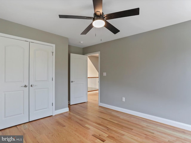 unfurnished bedroom with baseboards, a closet, light wood-style flooring, and a ceiling fan
