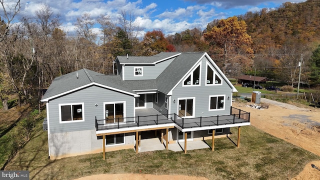 rear view of house with a deck and a lawn