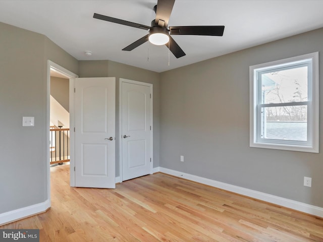 unfurnished bedroom with baseboards, ceiling fan, and light wood-type flooring