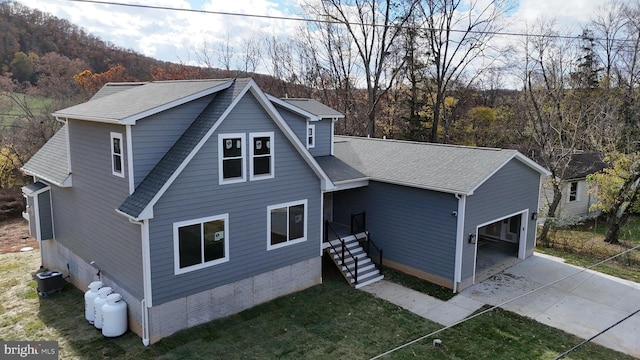 back of house with a garage and central air condition unit