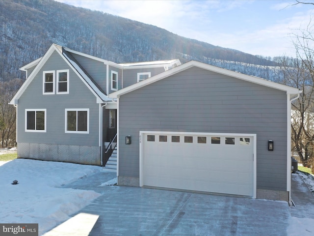 front of property with a garage and a mountain view