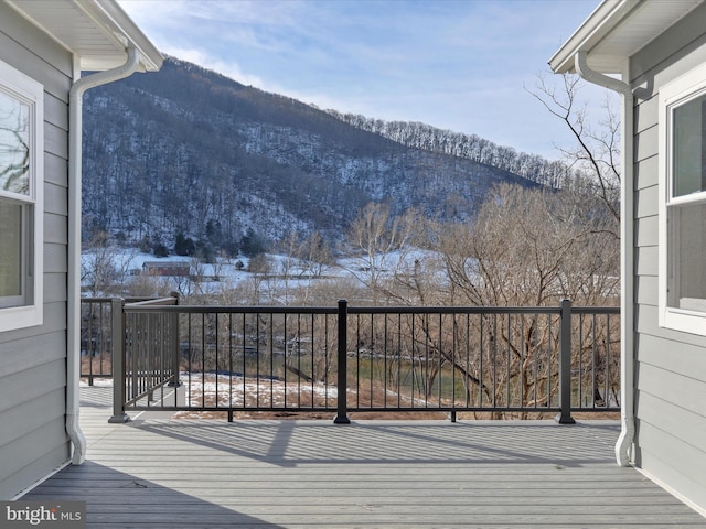 snow covered deck with a mountain view