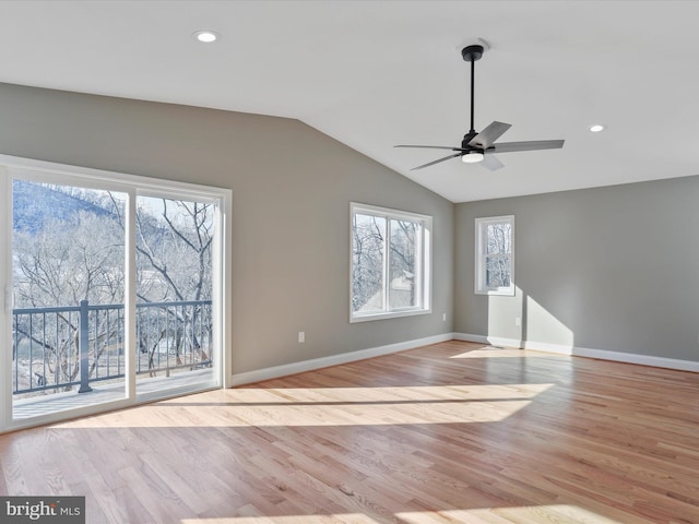 unfurnished living room with a ceiling fan, baseboards, light wood finished floors, and vaulted ceiling