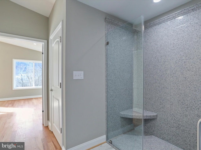 bathroom with hardwood / wood-style floors and a shower with shower door