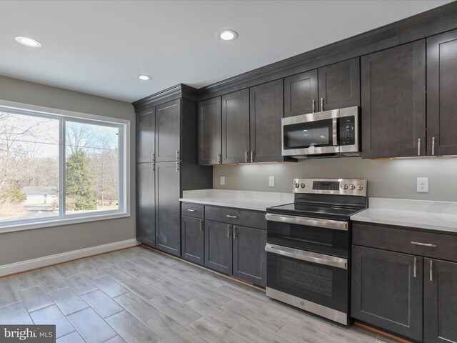 kitchen with appliances with stainless steel finishes and dark brown cabinets