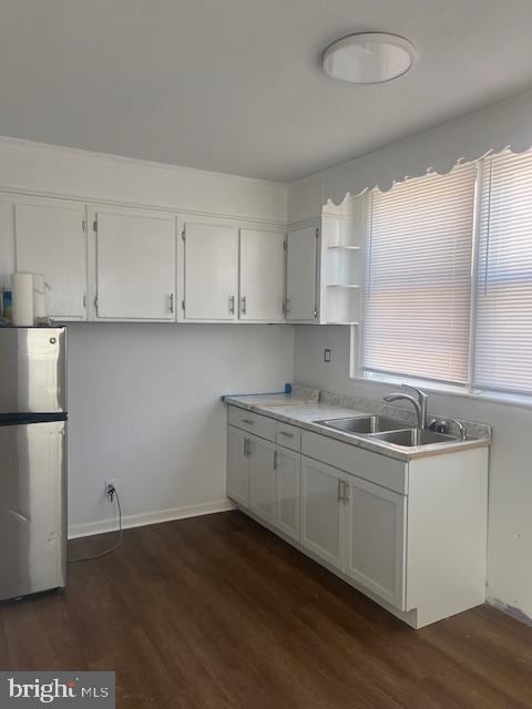 kitchen featuring white cabinets, sink, dark hardwood / wood-style flooring, and stainless steel fridge