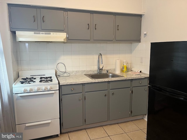 kitchen featuring sink, exhaust hood, black refrigerator, white range oven, and gray cabinets