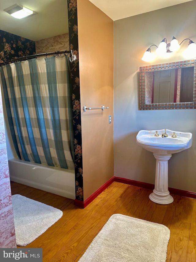 bathroom with shower / bath combo with shower curtain and hardwood / wood-style floors