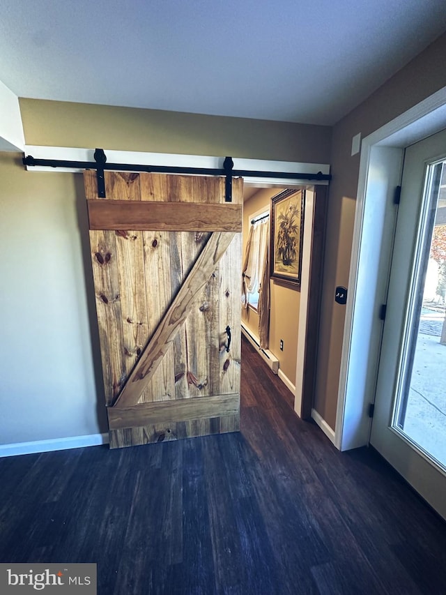 interior details featuring a barn door, hardwood / wood-style flooring, and a baseboard radiator