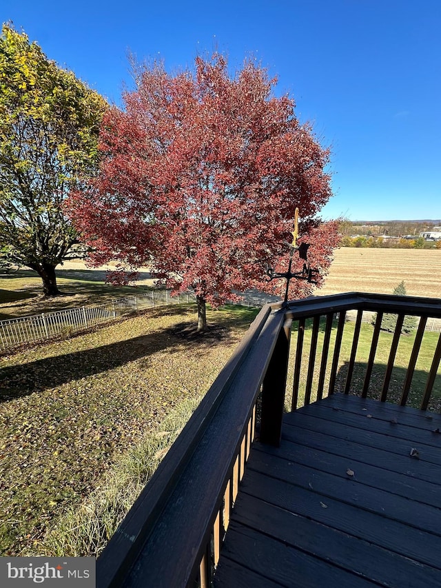 deck with a yard and a rural view