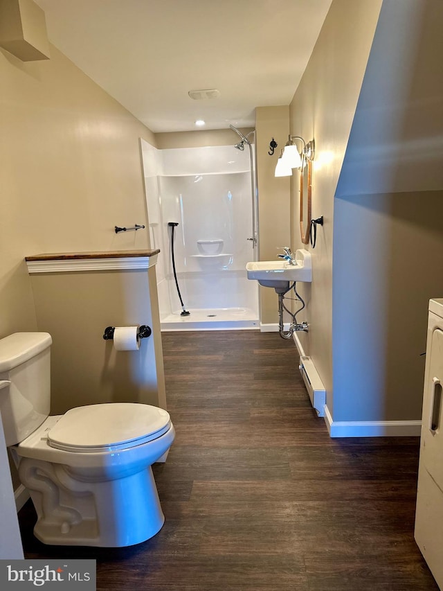 bathroom featuring a baseboard radiator, wood-type flooring, toilet, sink, and walk in shower