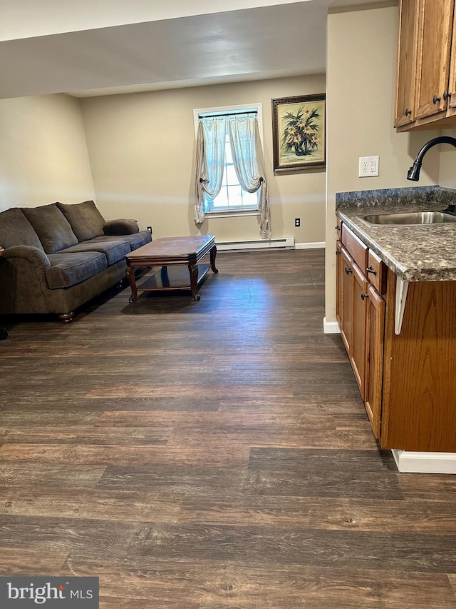 living room featuring a baseboard radiator, dark wood-type flooring, and sink