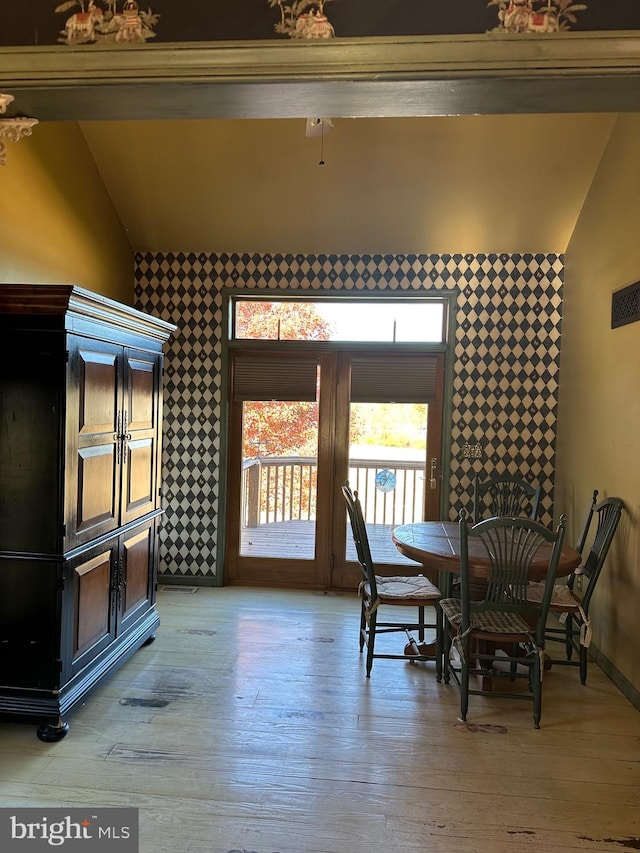 dining room featuring light hardwood / wood-style floors and lofted ceiling