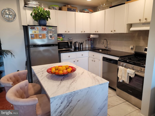 kitchen featuring white cabinets, appliances with stainless steel finishes, decorative backsplash, and sink