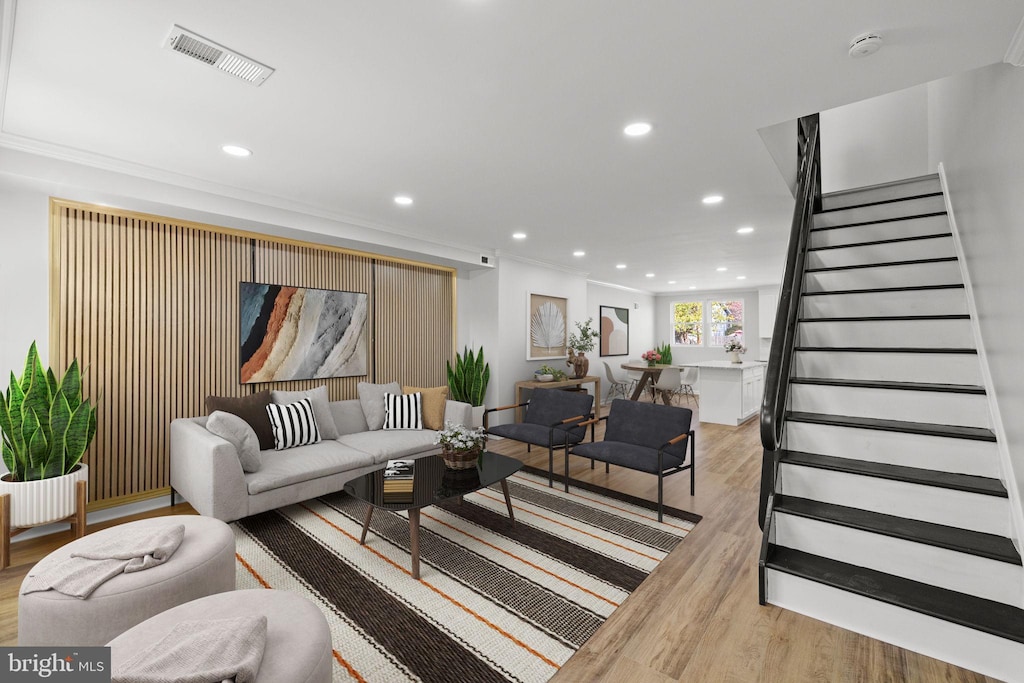 living room with ornamental molding and light wood-type flooring