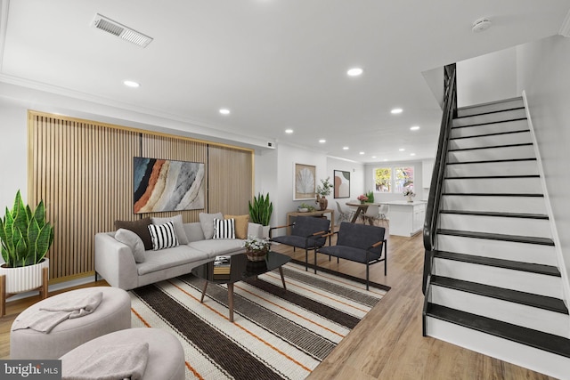 living room with ornamental molding and light wood-type flooring