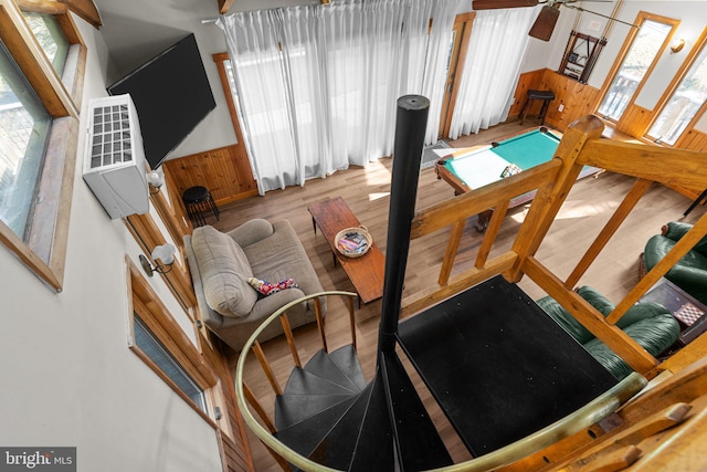 interior space with wood-type flooring, wooden walls, and heating unit