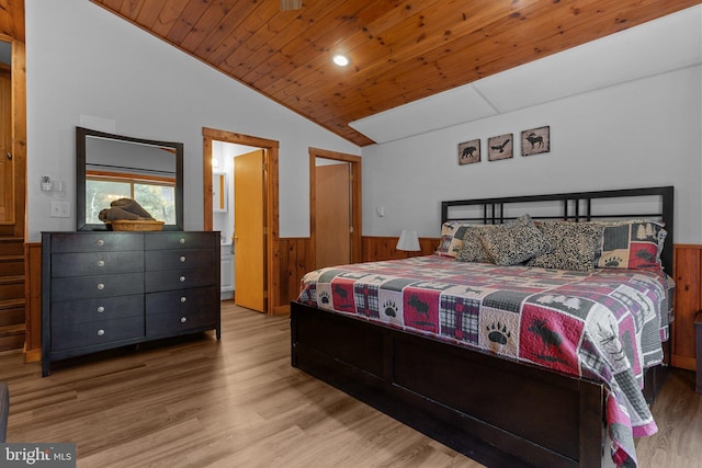 bedroom featuring light hardwood / wood-style floors, wooden ceiling, wooden walls, and vaulted ceiling