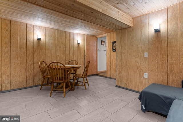 dining room with wooden ceiling and wood walls