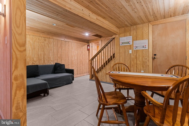 dining area with wooden ceiling and wood walls