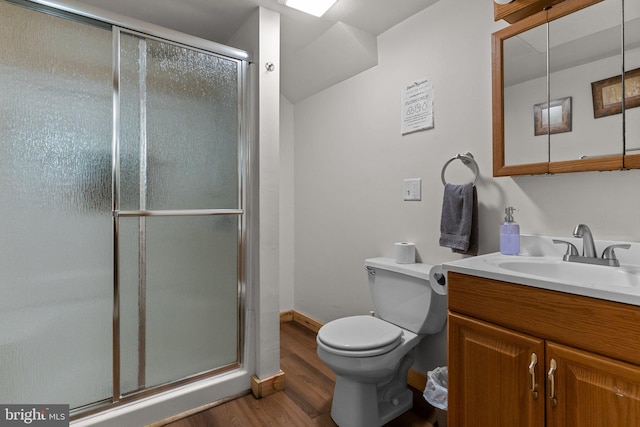 bathroom with hardwood / wood-style floors, vanity, toilet, and an enclosed shower