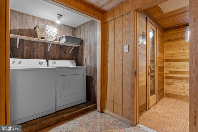 laundry room with wooden ceiling, separate washer and dryer, and wooden walls