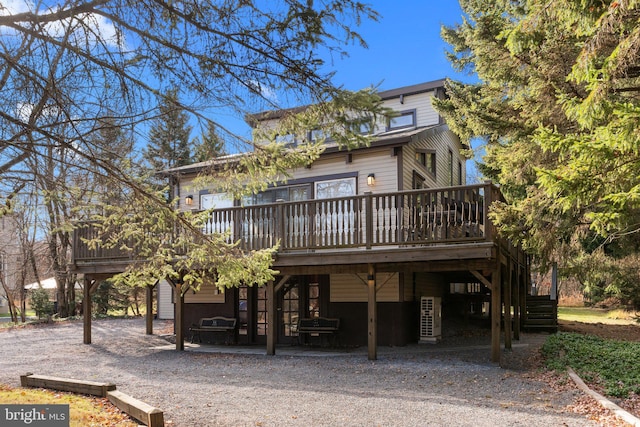 rear view of property featuring a wooden deck