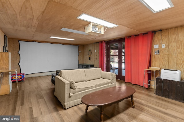 living room with wood walls, french doors, wood ceiling, and light hardwood / wood-style floors