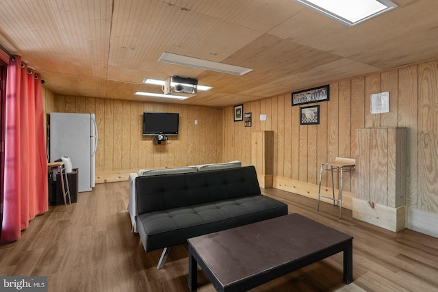 sitting room with hardwood / wood-style floors, wooden walls, and wooden ceiling