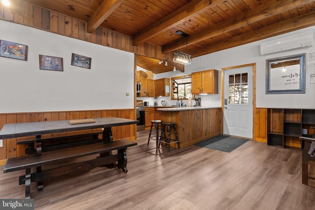 dining area featuring wood ceiling, a wall unit AC, sink, beamed ceiling, and light hardwood / wood-style floors