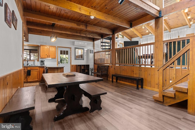 dining space featuring wooden ceiling, an AC wall unit, rail lighting, beamed ceiling, and light hardwood / wood-style floors